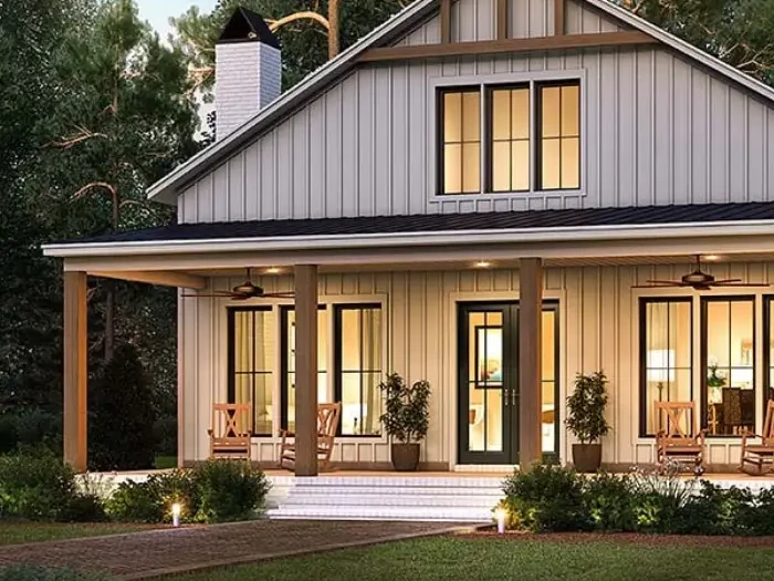 Barndominium design with board-and-batten siding, a covered front porch on wood posts, rocking chairs and a white chimney
