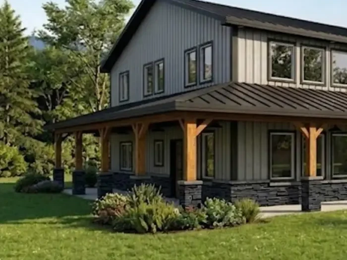 Two-story barndominium design with gray vertical metal siding, a dark metal roof, a stone wainscot and a wraparound porch on timber posts