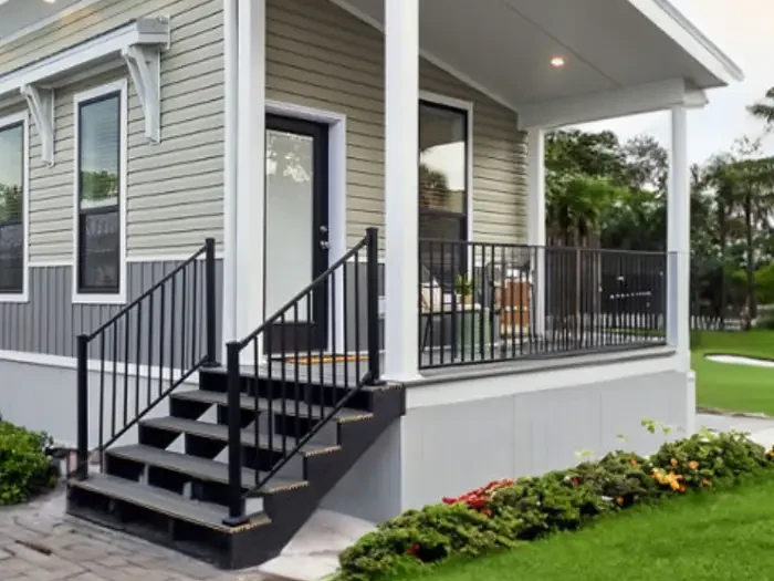 Small detached ADU with gray siding, a covered porch and its own front steps and door