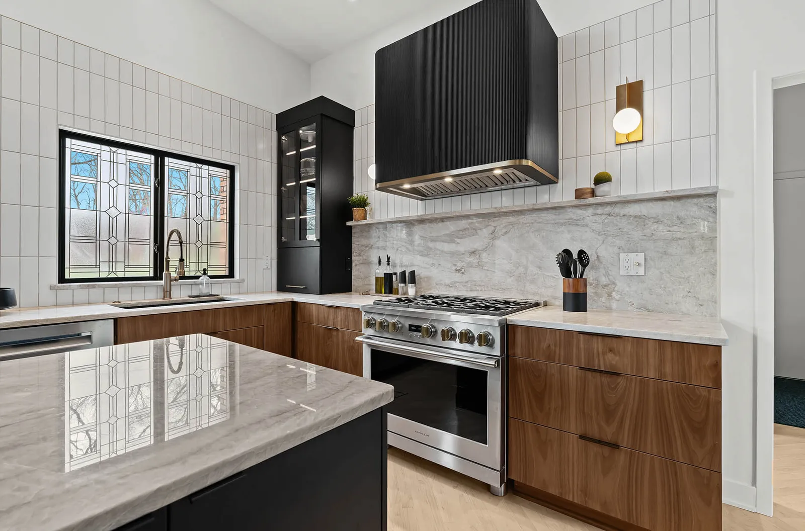 Mid-century kitchen with fluted black range hood and quartzite backsplash