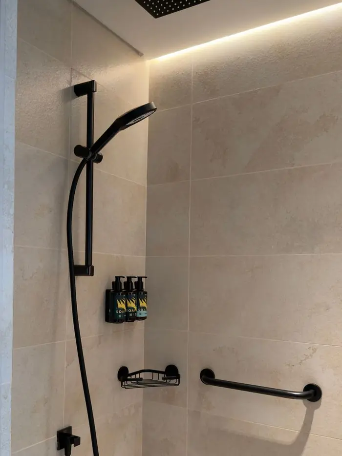 Contemporary shower area with matte black fixtures and tiled surround